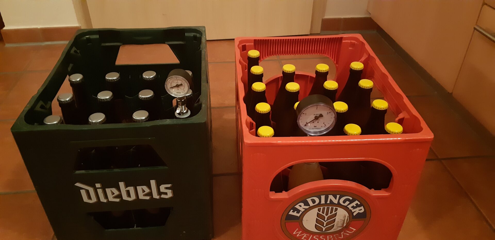 Zwei Kisten mit Bier in der Nachgärung und Flaschenmanometer