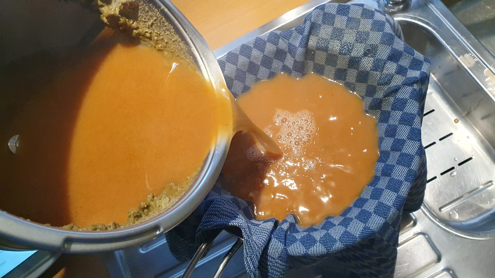 Abseihen nach dem Kochen: Hopfen und Trub setzen das Küchentuch zu